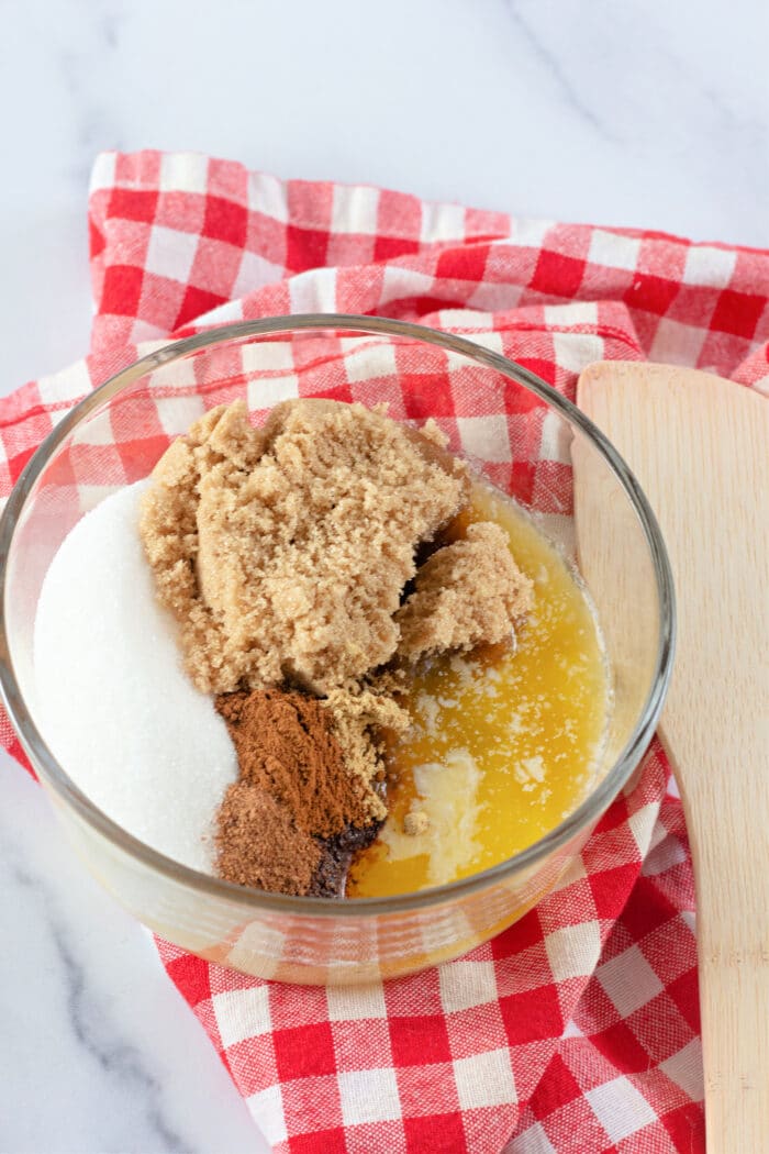 brown sugar, melted butter, sugar, and spices in a clear mixing bowl.