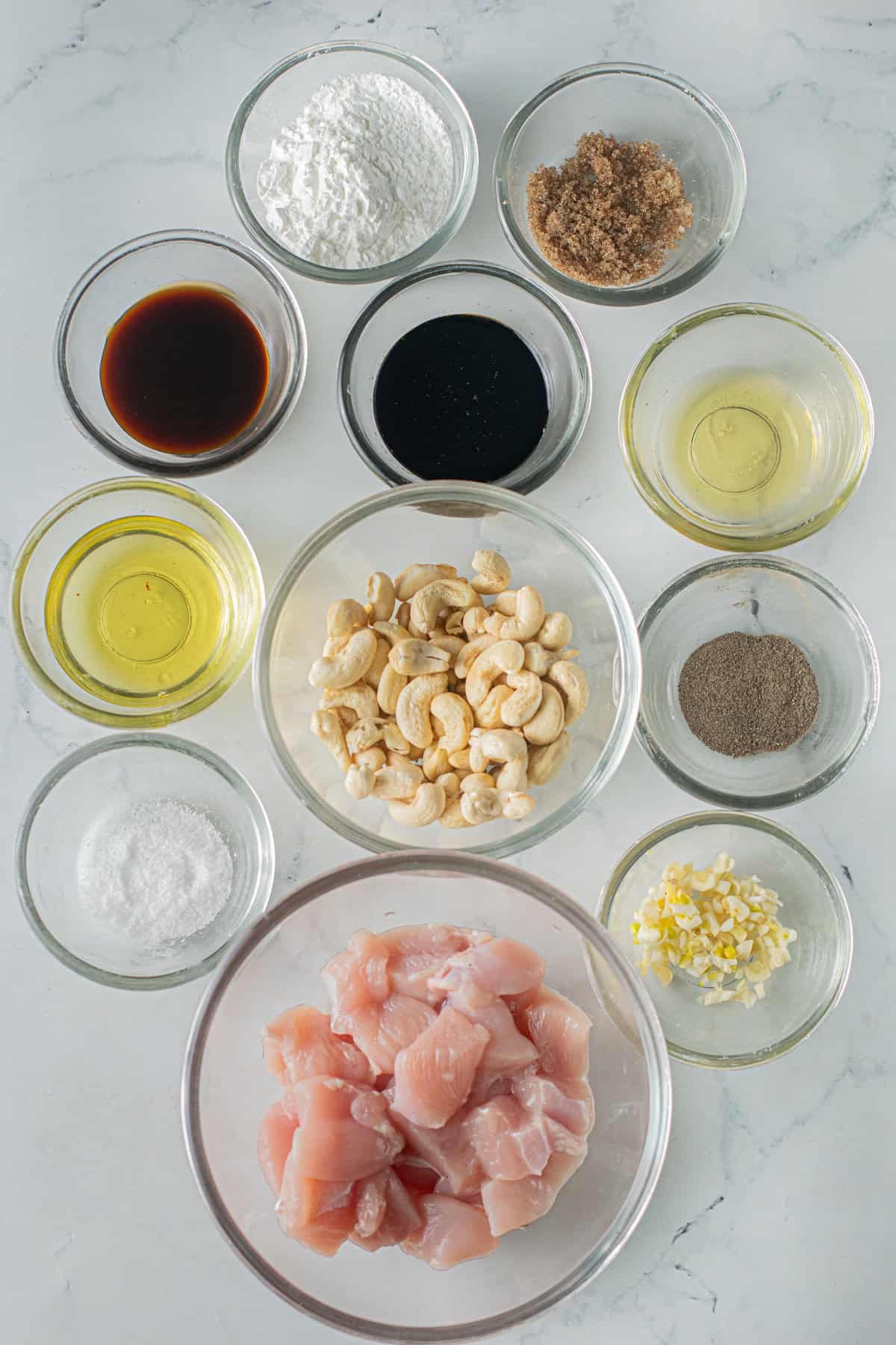 Tender, juicy pieces of chicken and toasted cashews are tossed in a sticky sweet-but-savory garlic sauce in this Cashew Chicken recipe. Overhead view of ingredients needed to make cashew chicken