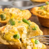 A fork diving into a chicken pot pie muffin
