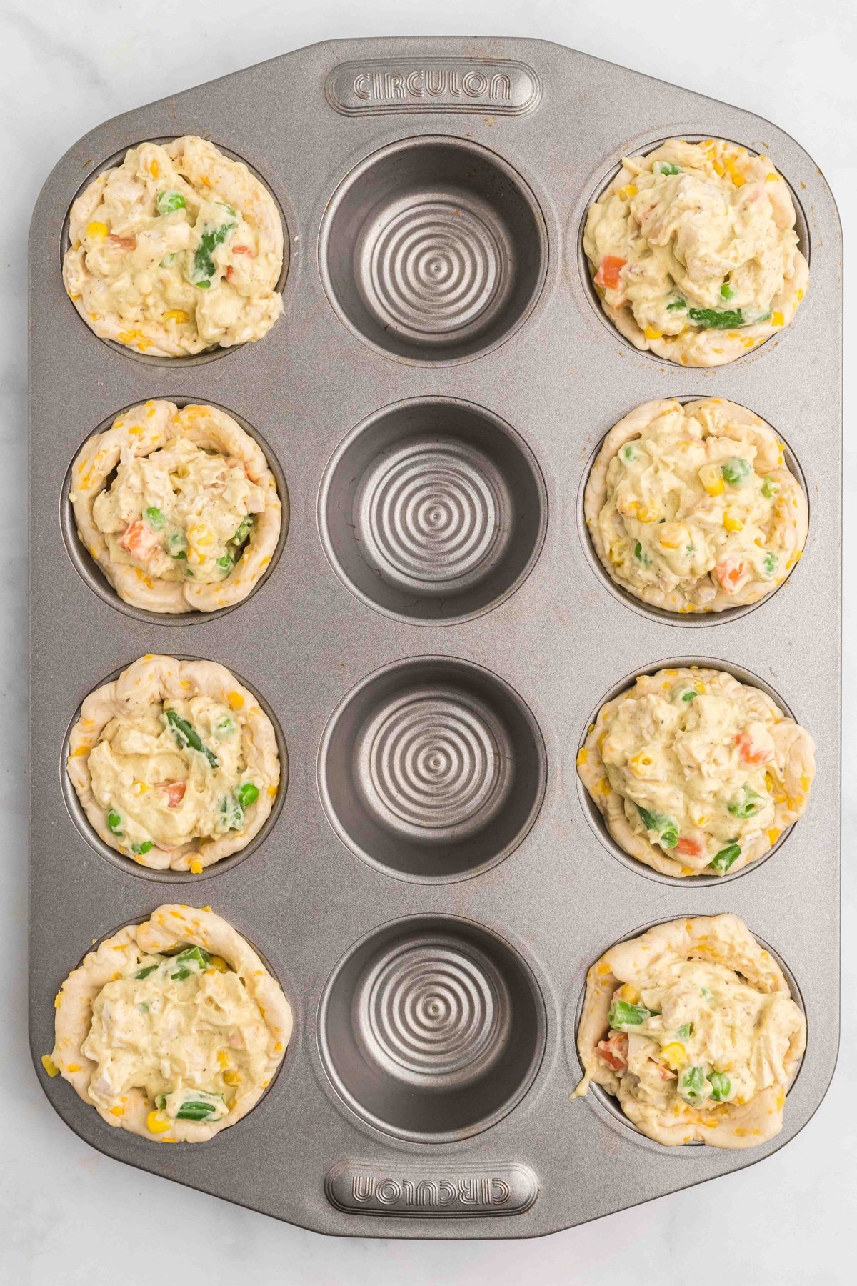 Muffin tin chicken pot pies ready to be baked