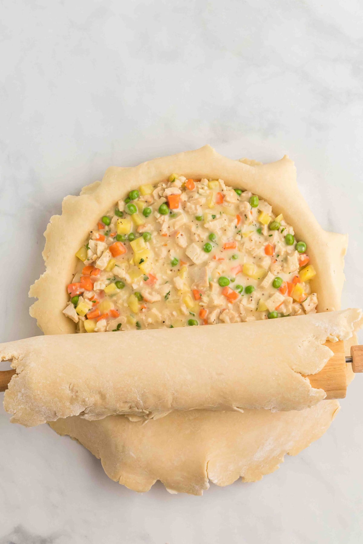 A second pie crust being rolled out on top of a pot pie