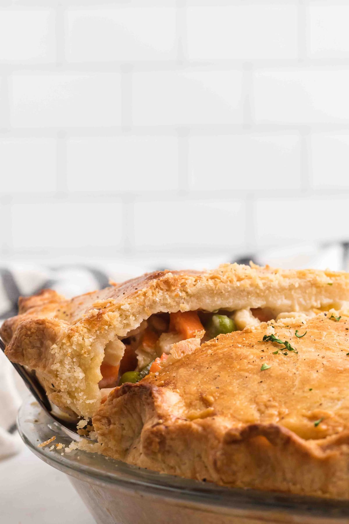 A slice of chicken pot pie being served from the pan