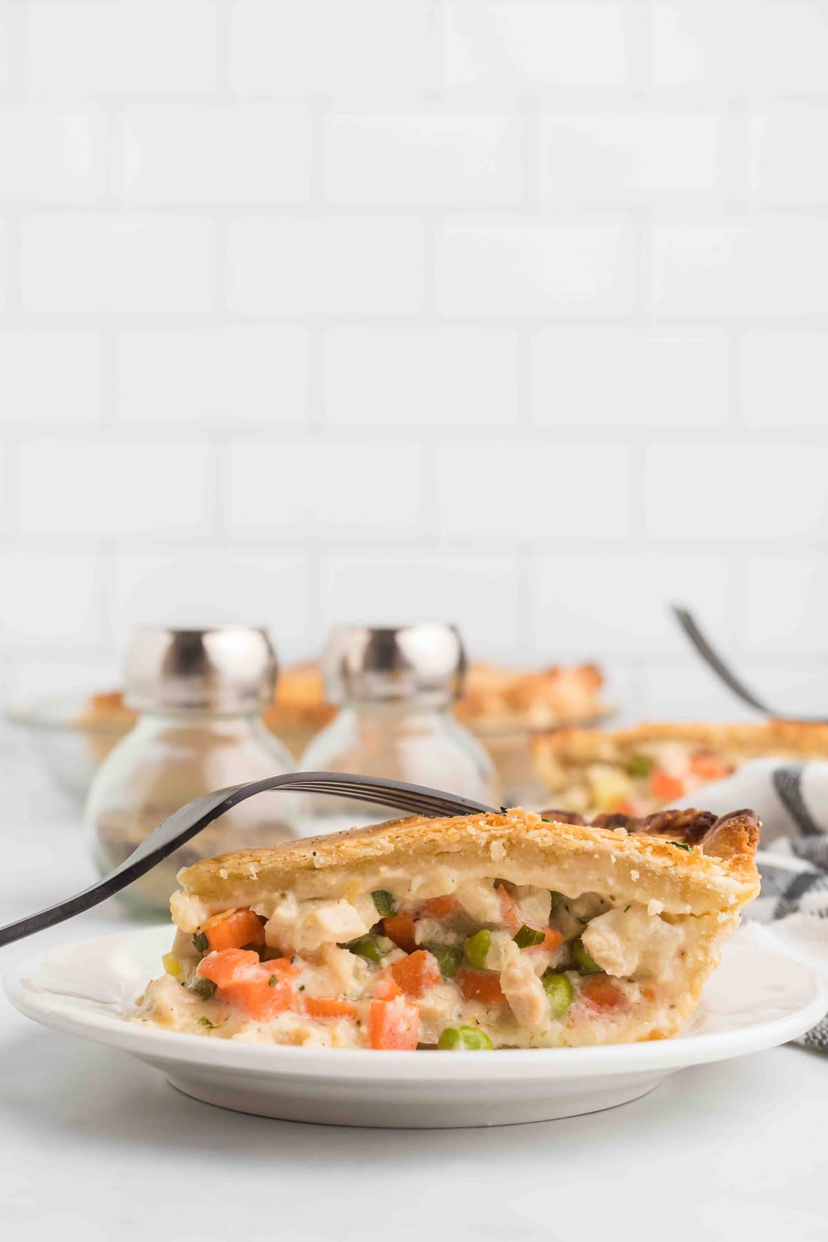 A slice of chicken pot pie on a white plate