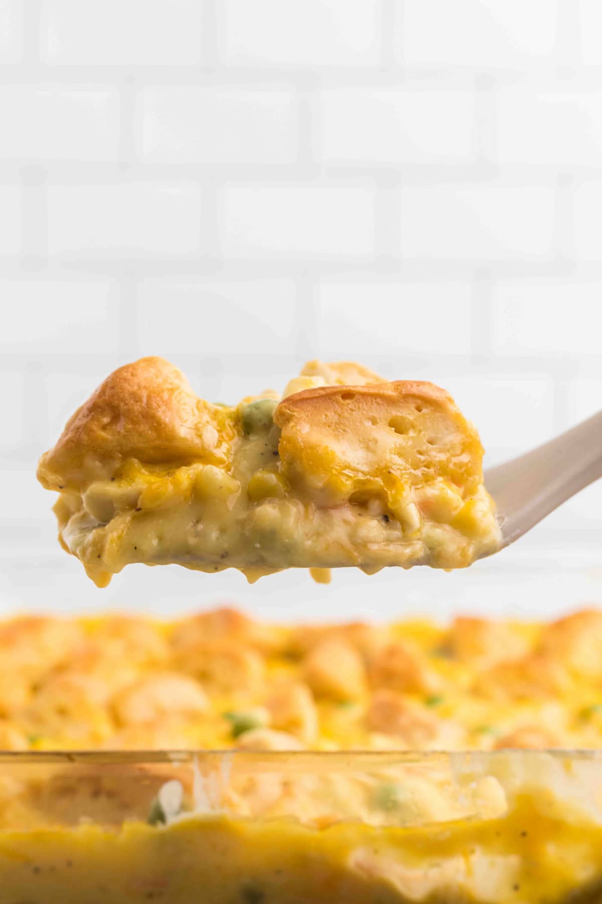 A spatula serving chicken pot pie with biscuits