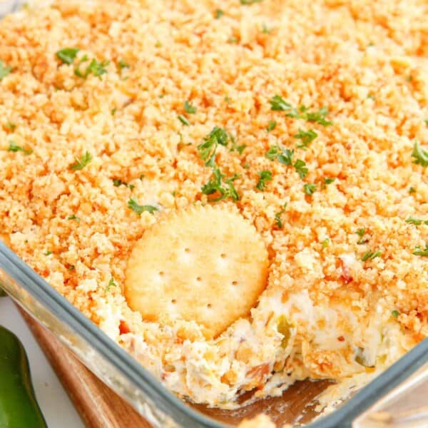 A Ritz cracker in a pan of jalapeno popper dip