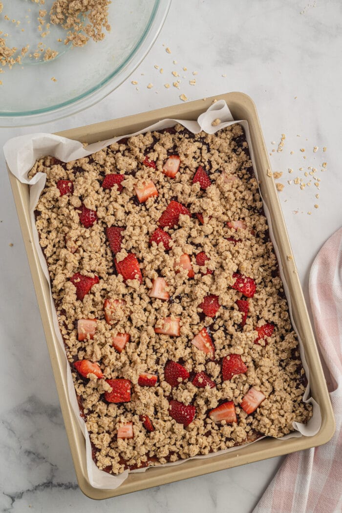 Assembled strawberry oatmeal bars in a baking pan.
