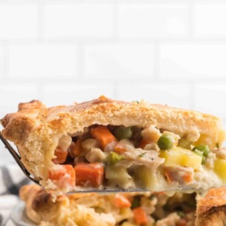 A slice of chicken pot pie on a spatula being served from the pan