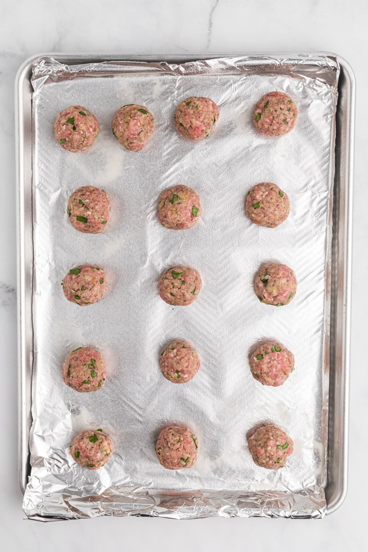Meatballs ready to be baked on a baking sheet
