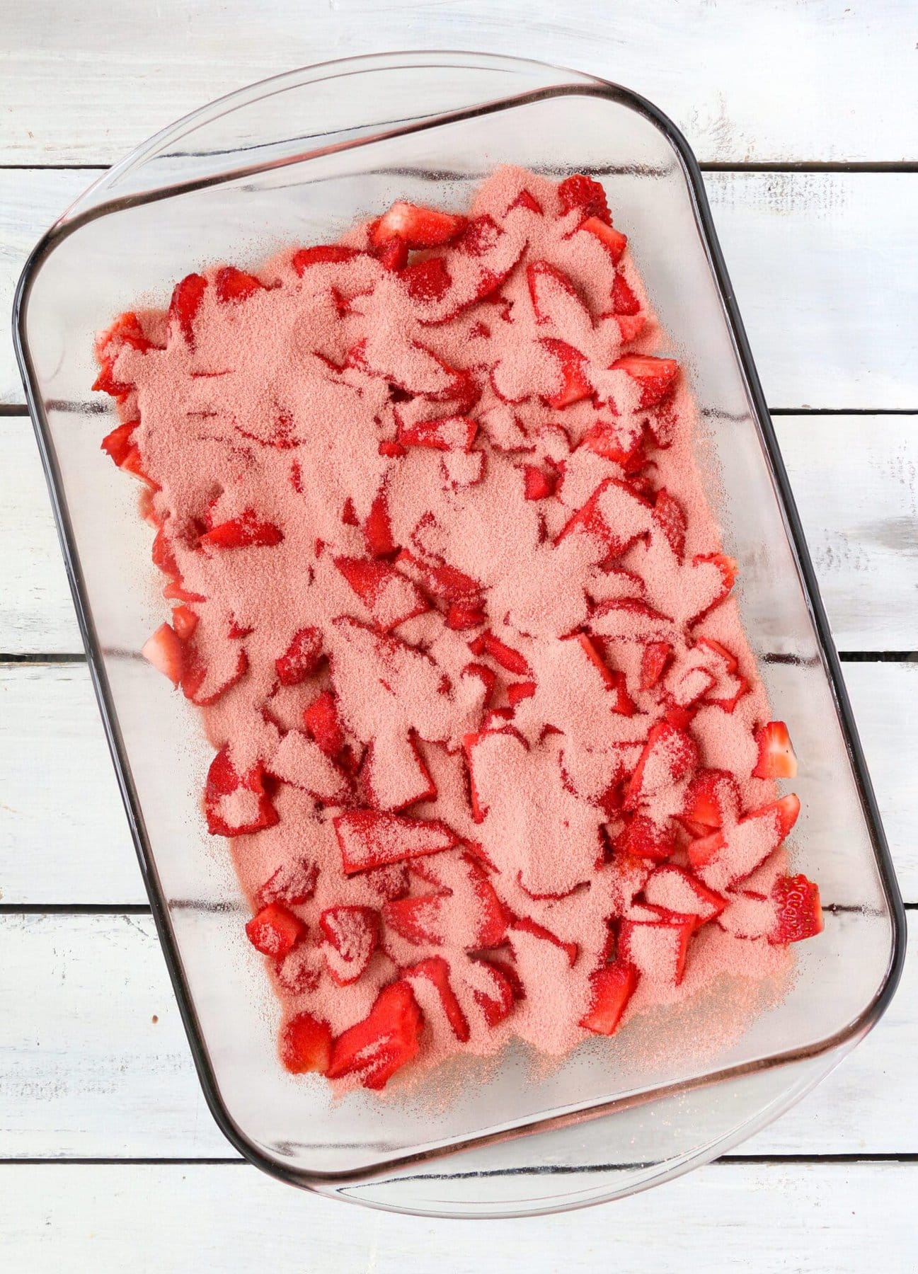 Coating the strawberries in jello mix.