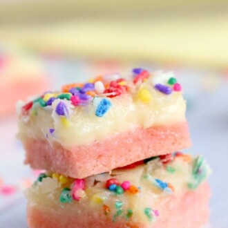 Two ooey gooey bars with rainbow sprinkles stacked on top of each other.