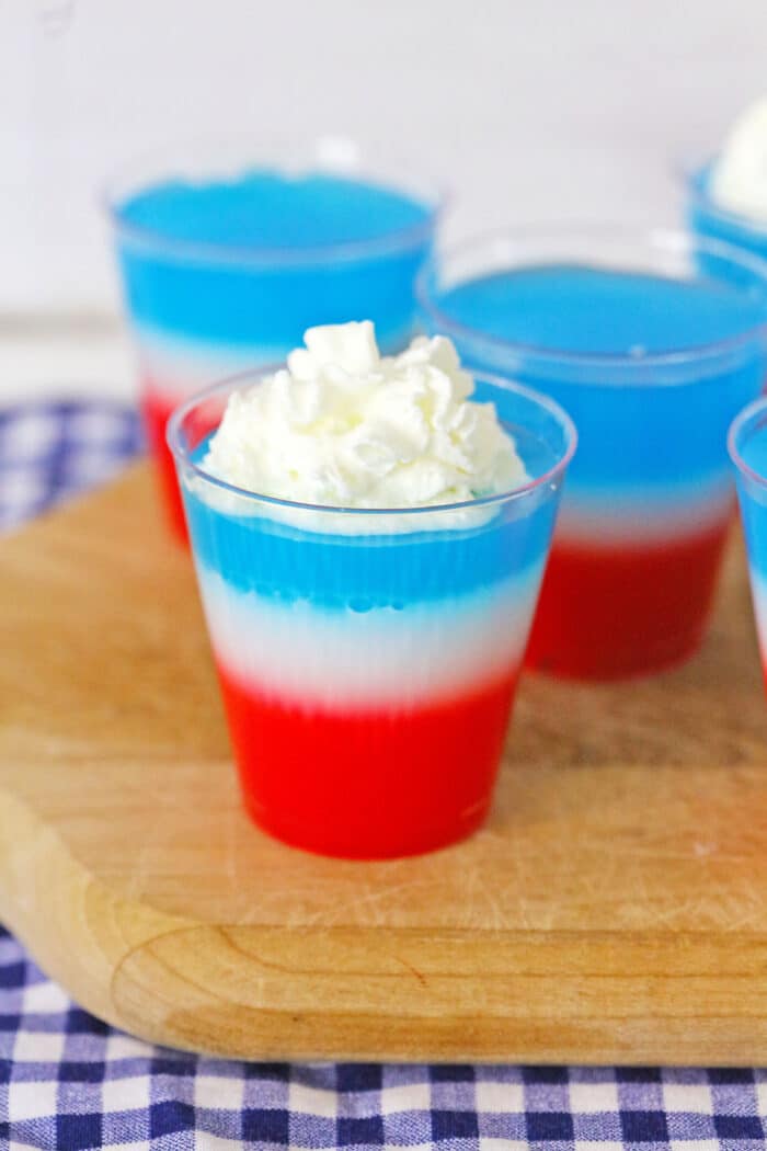 red, white and blue jello shots on a cutting board