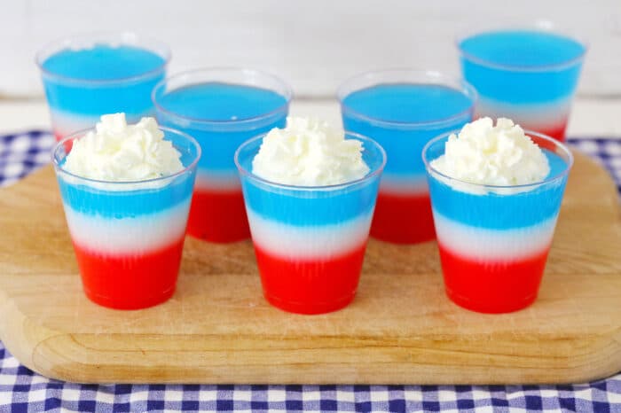 red, white and blue jello shots on a cutting board