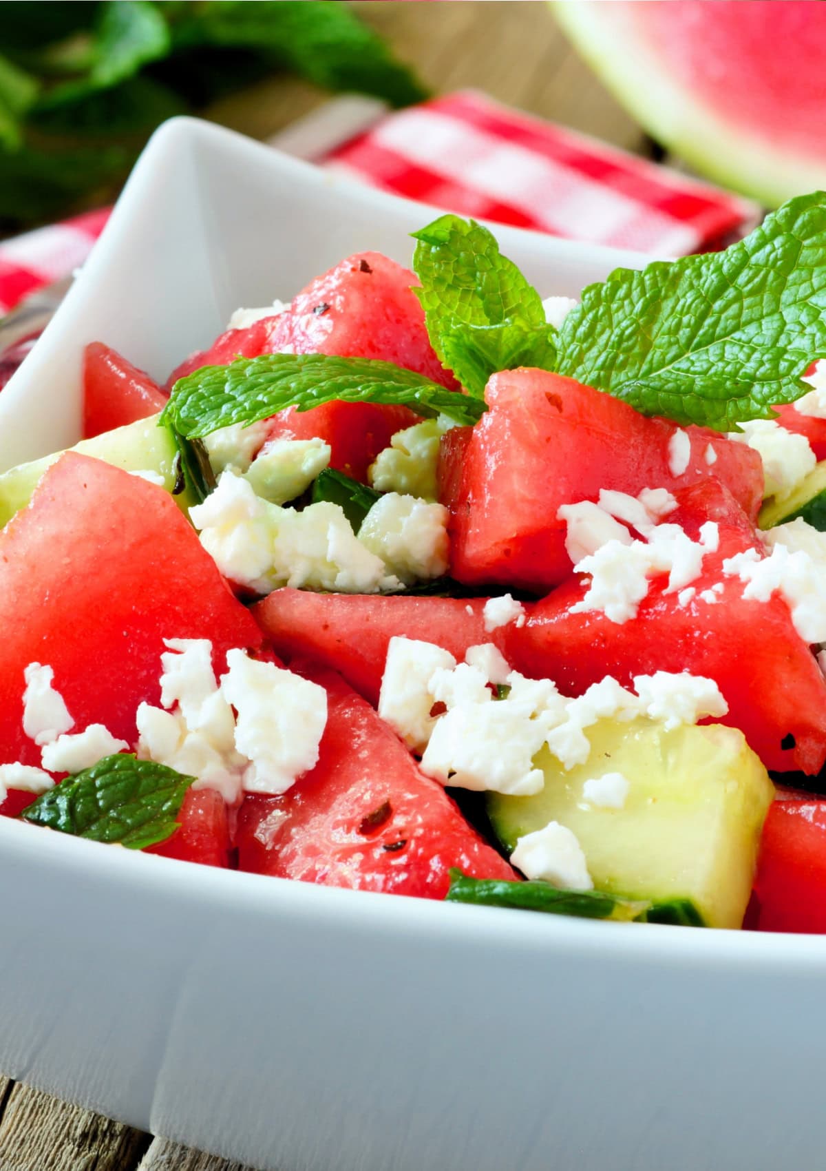 This cool watermelon salad with fresh basil, cucumbers, feta cheese, and homemade dressing is the only salad you'll want to make this summer! Watermelon Salad in a bowl