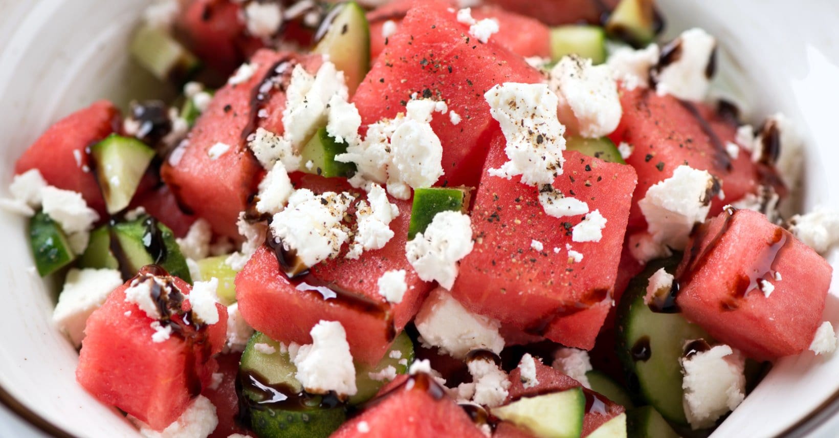 Close up of watermelon feta salad drizzled with dressing.