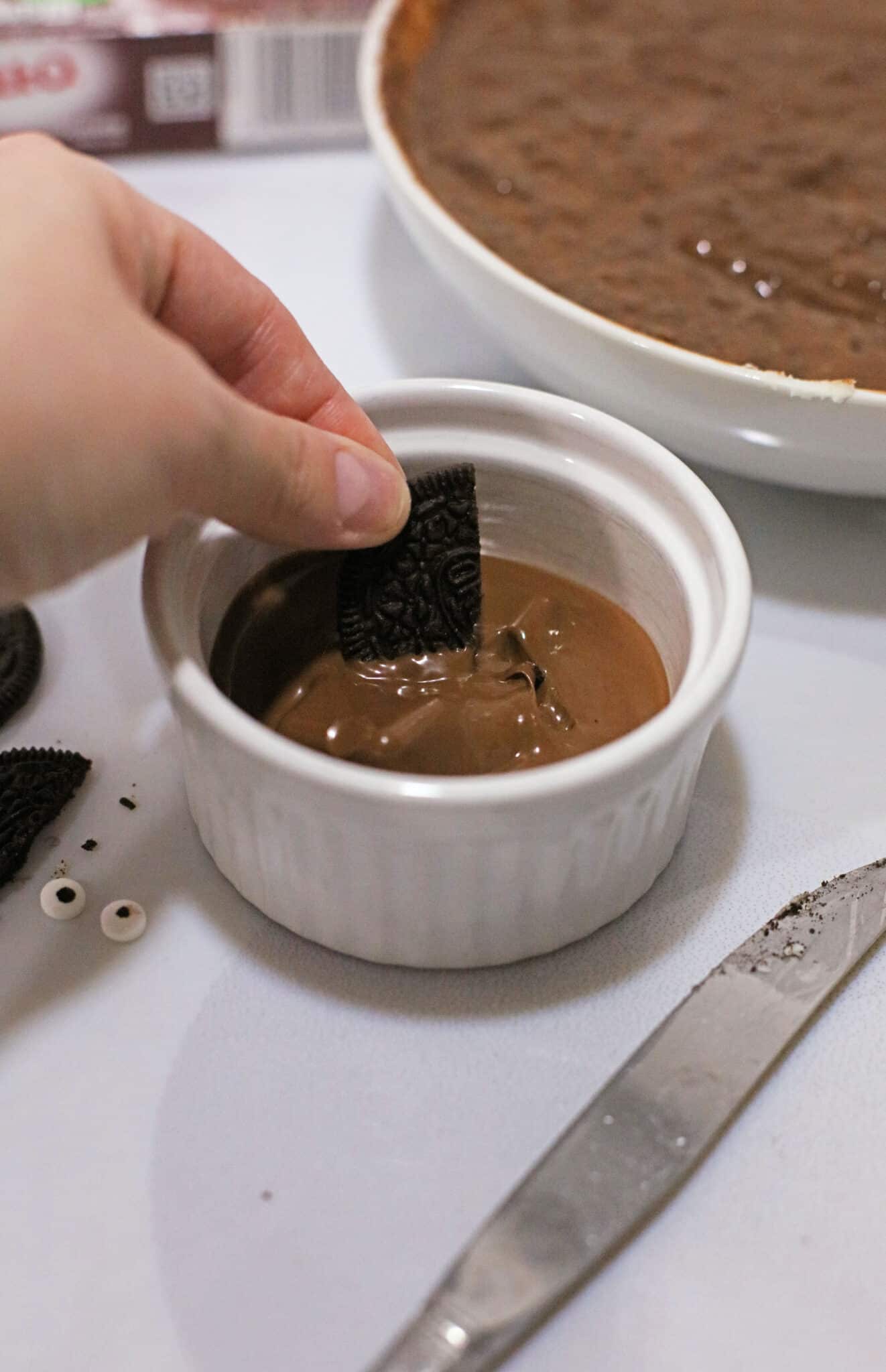 Dipping the Oreo in chocolate.