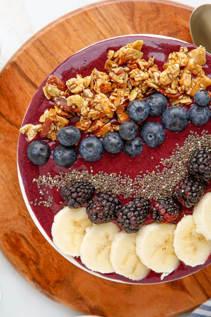 Blueberry Smoothie Bowl topped with fruits and oat clusters.