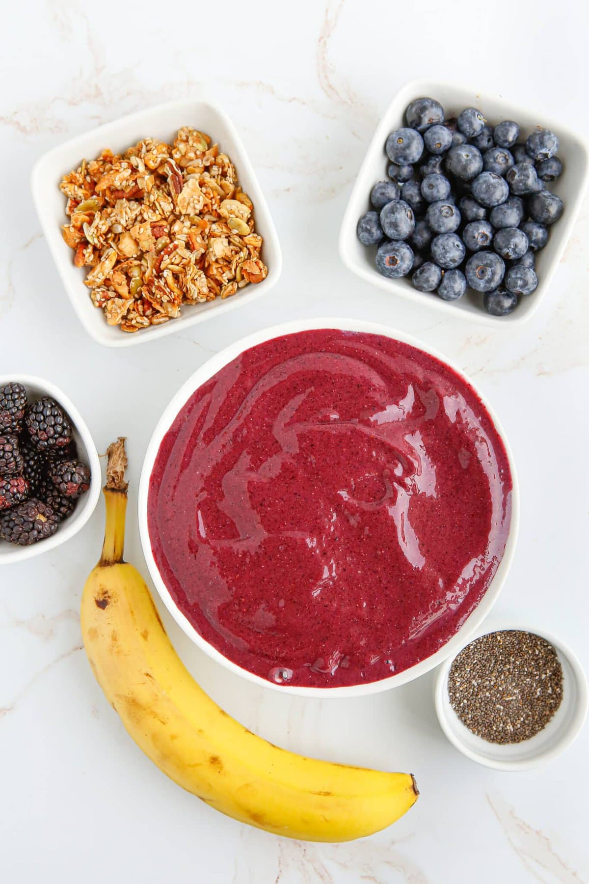 The bowl of smoothie surrounded by ingredients.
