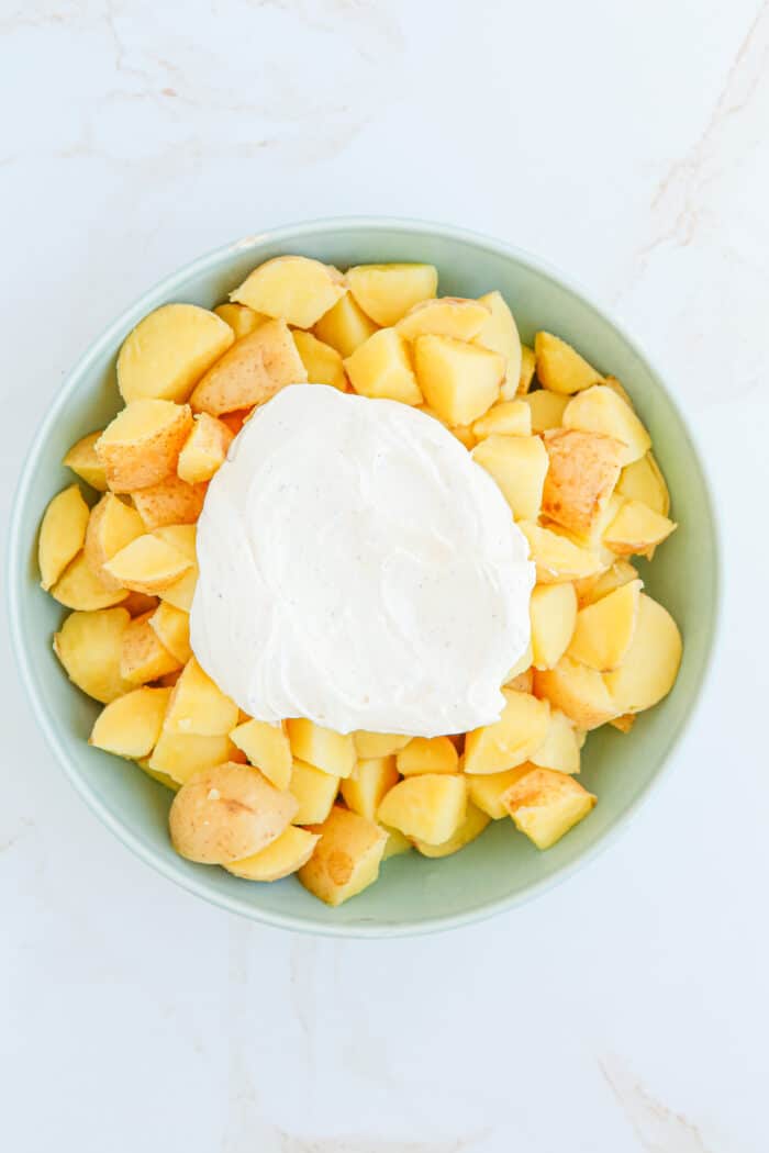 Adding the sour cream to the potatoes.
