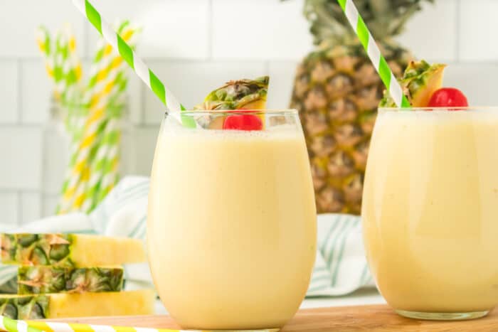 Pineapple Smoothie with a green straw.