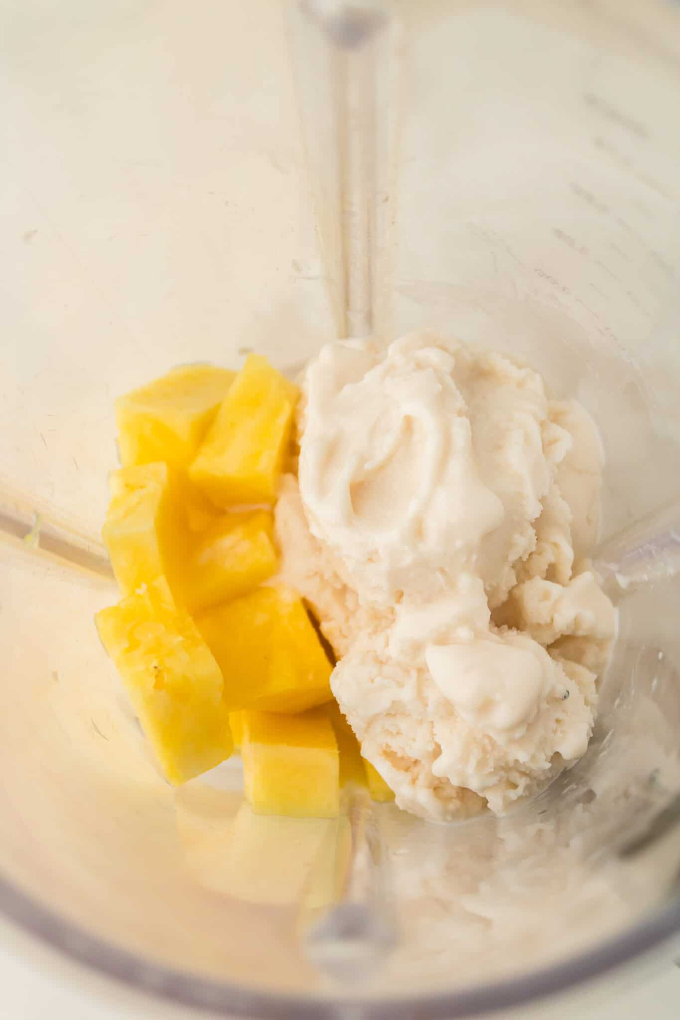 Adding the pineapple and ice cream into the blender.