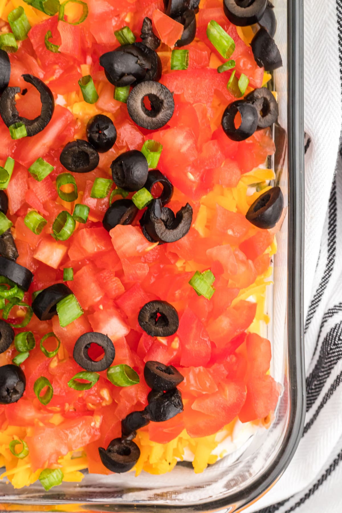 The corner of a baking dish of 7 layer dip