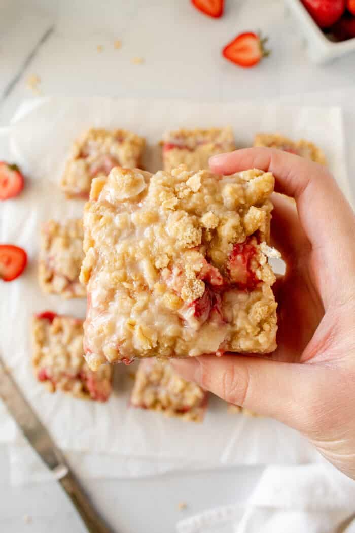 A hand holding the Strawberry Crumb Bar.