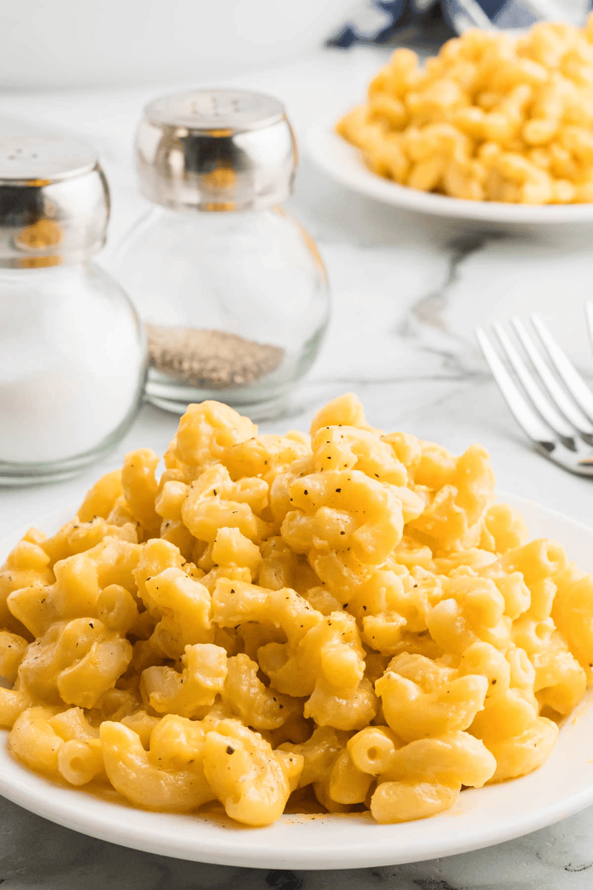 Mac and cheese on a plate topped with pepper.