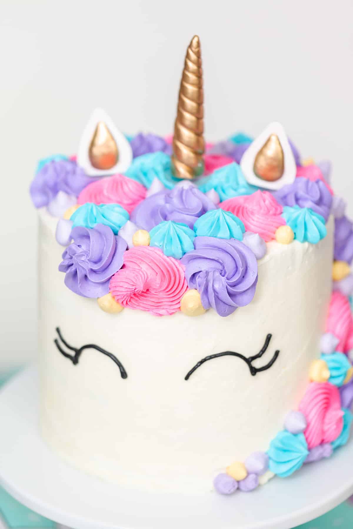 Front view of a homemade unicorn cake with a pastel mane