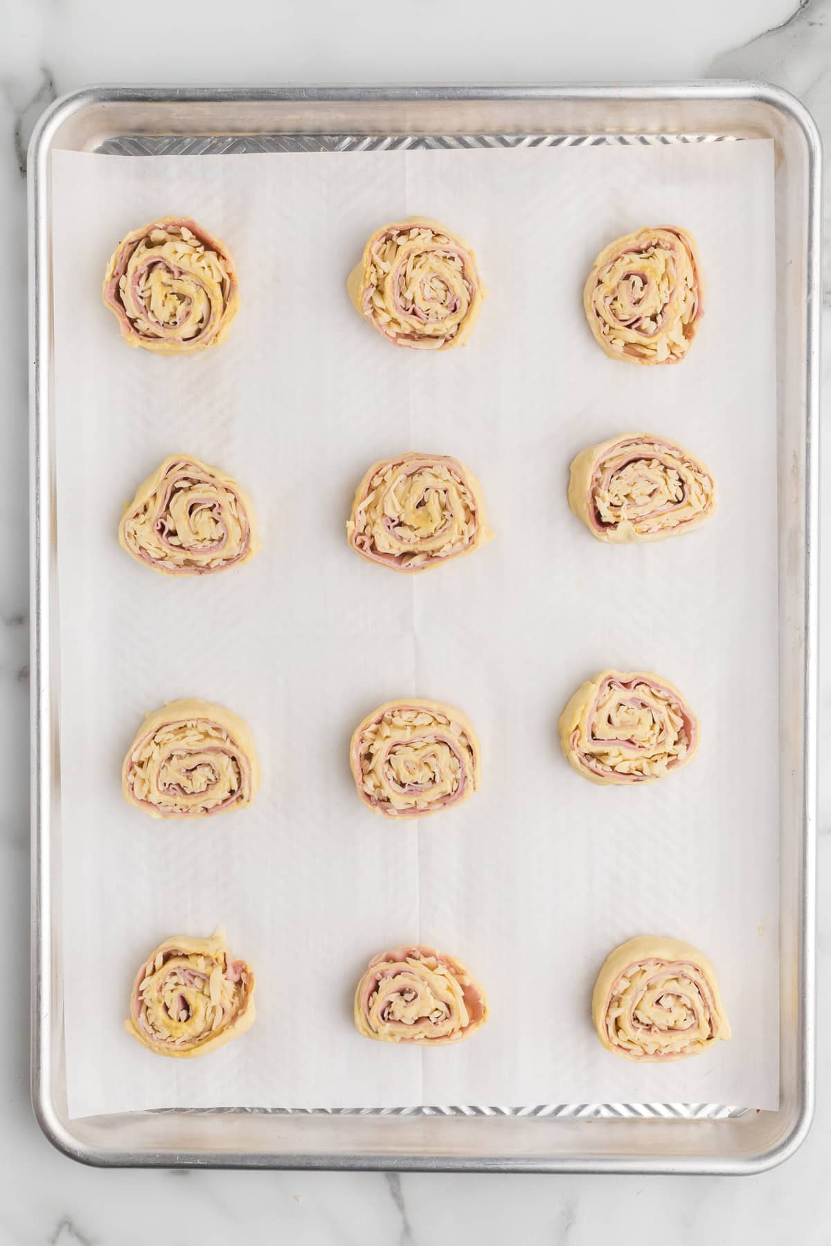 Overhead view of unbaked ham and cheese pinwheels