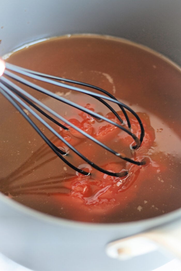 whisking together ingredients to make a sauce.