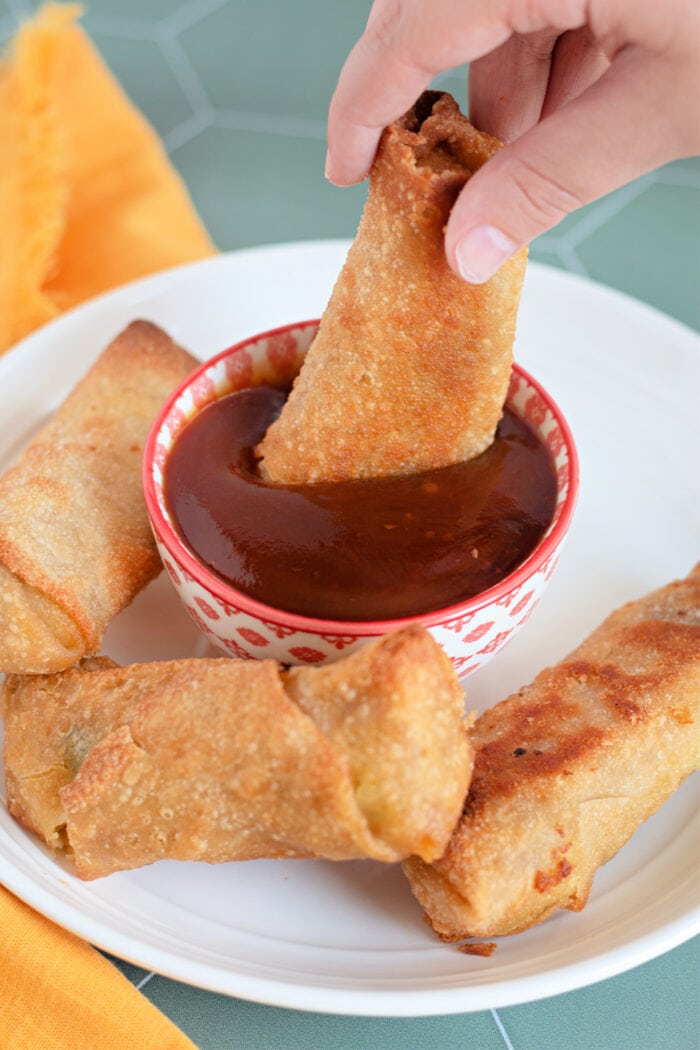 Dipping an egg roll into homemade sweet and sour sauce.
