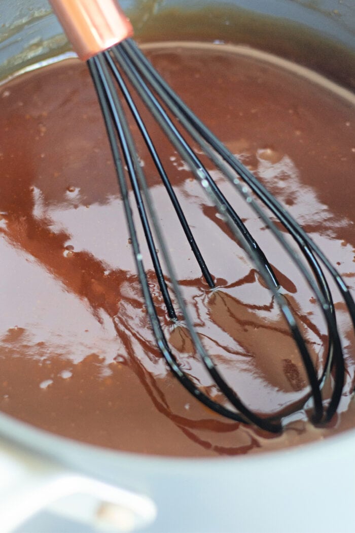 freshly made sauce in a saucepan with a whisk.