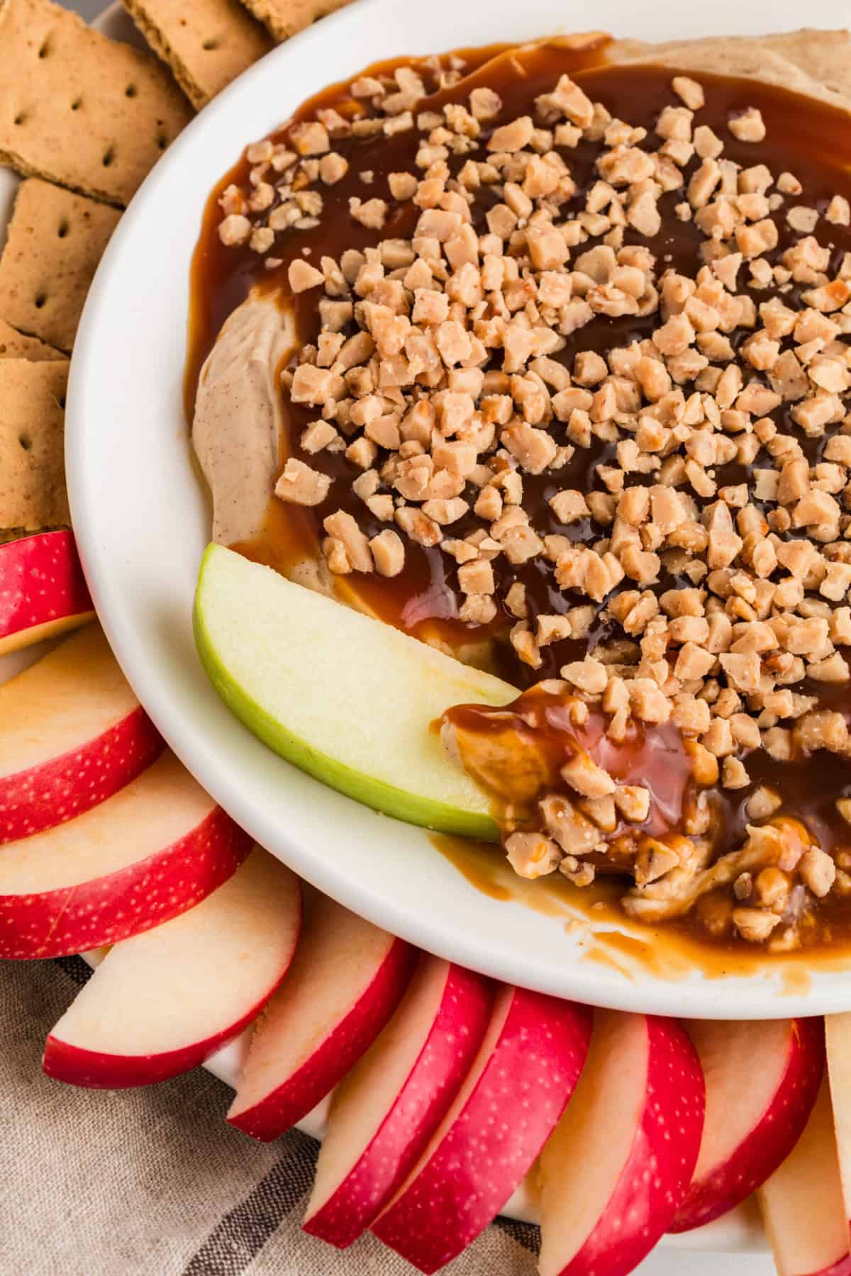 Ready in 5 minutes, this Caramel Apple Dip is made with cream cheese, brown sugar, and caramel sauce for an easy fall treat. Caramel Apple Dip in a bowl with apples and graham crackers