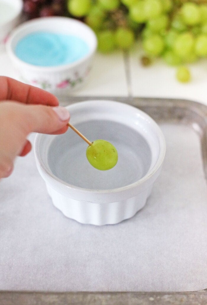 dipping a grape into water