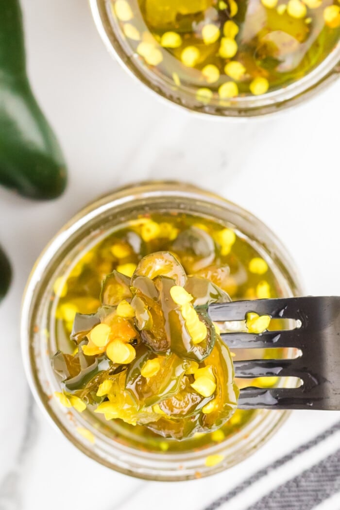 Candied Jalapenos in jars on a table.