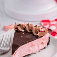 A slice of peppermint cheesecake on a white plate