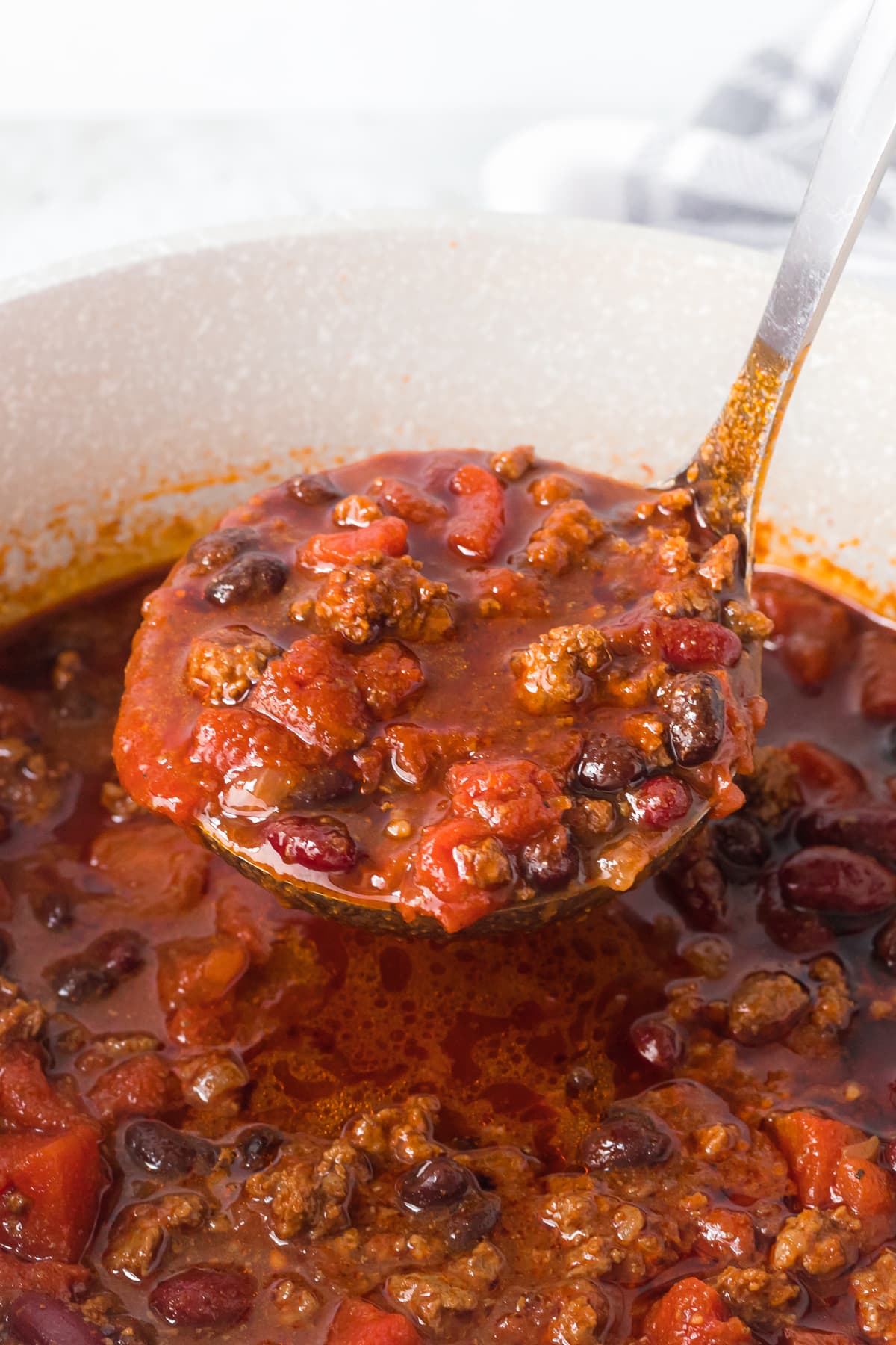 Chili being scooped out of a pot.