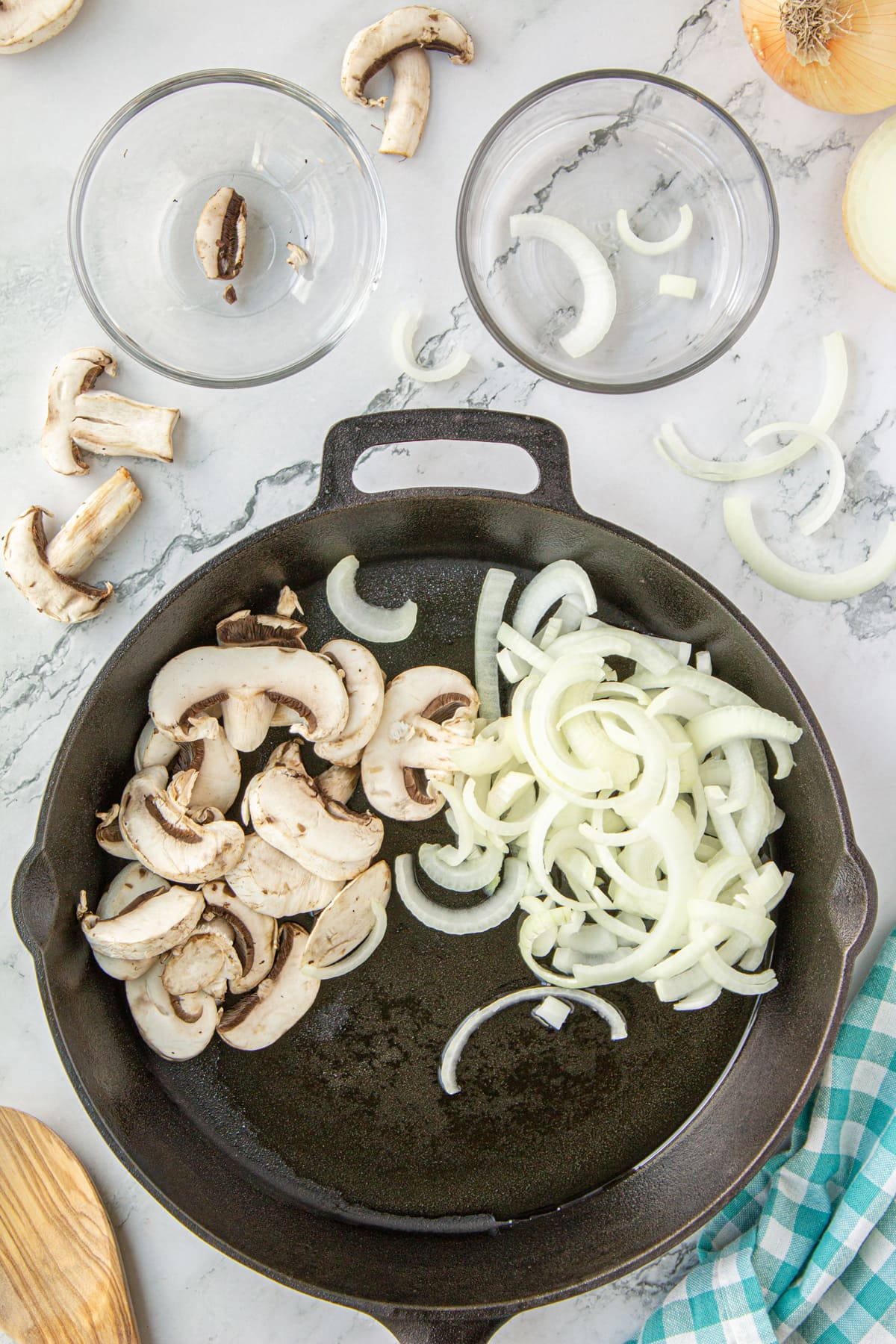 Chopped mushrooms and sliced onions in a skillet.