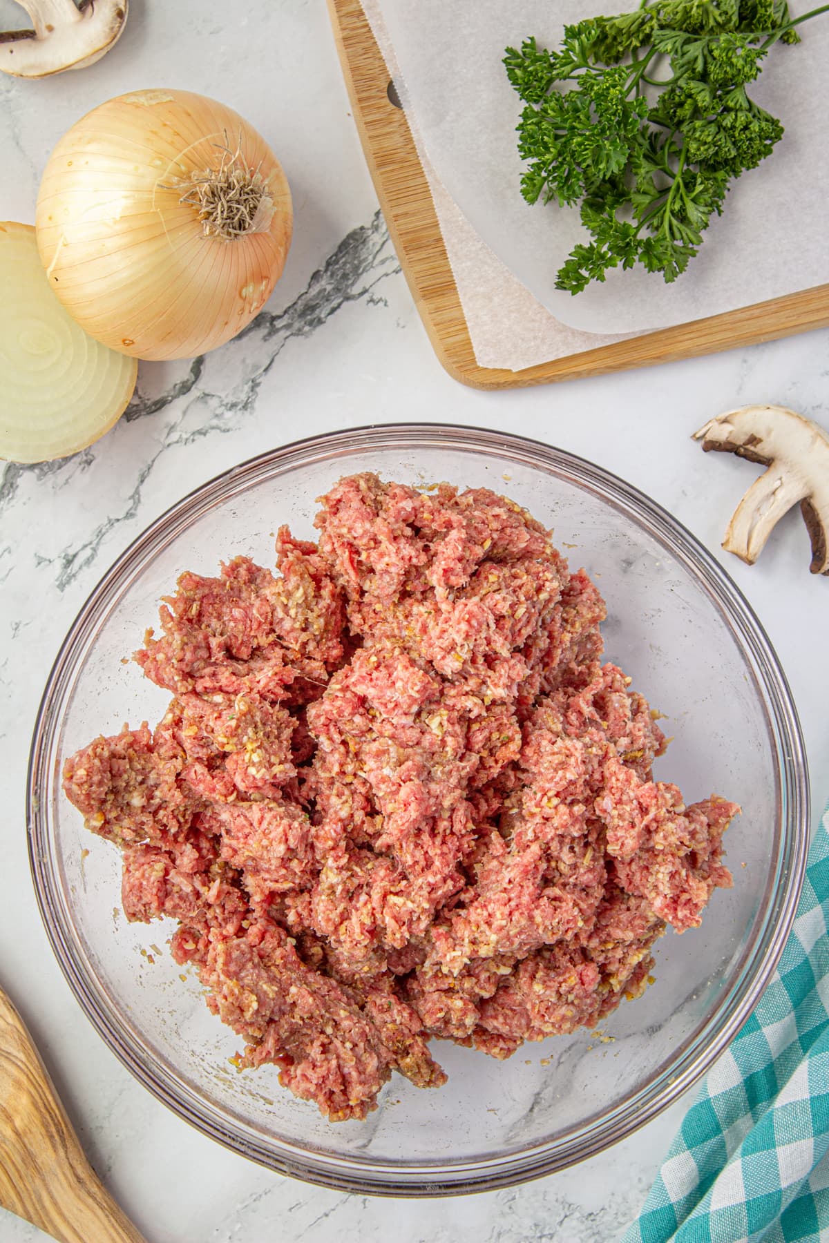 Seasonings mixed into ground beef in a bowl.