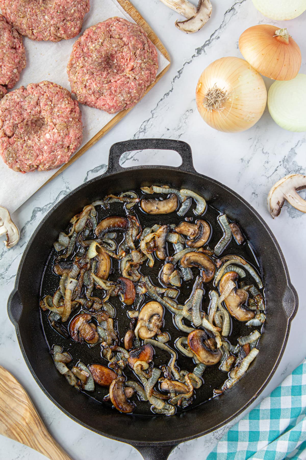 Sauteed mushrooms and onions in the bottom of a skillet.
