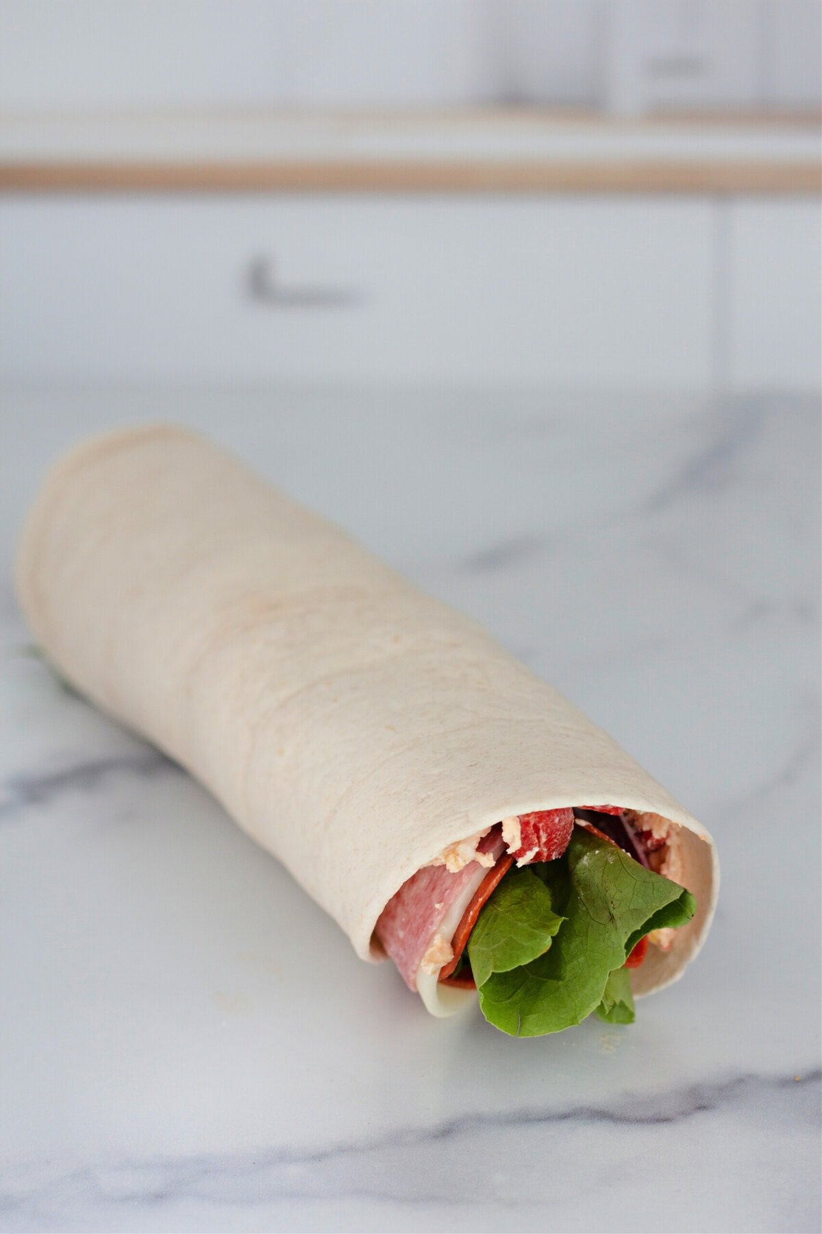 A filled flour tortilla rolled into a log.
