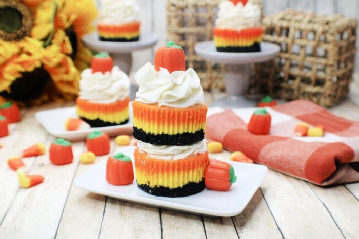 Mini Candy Corn Cheesecakes on a white table.