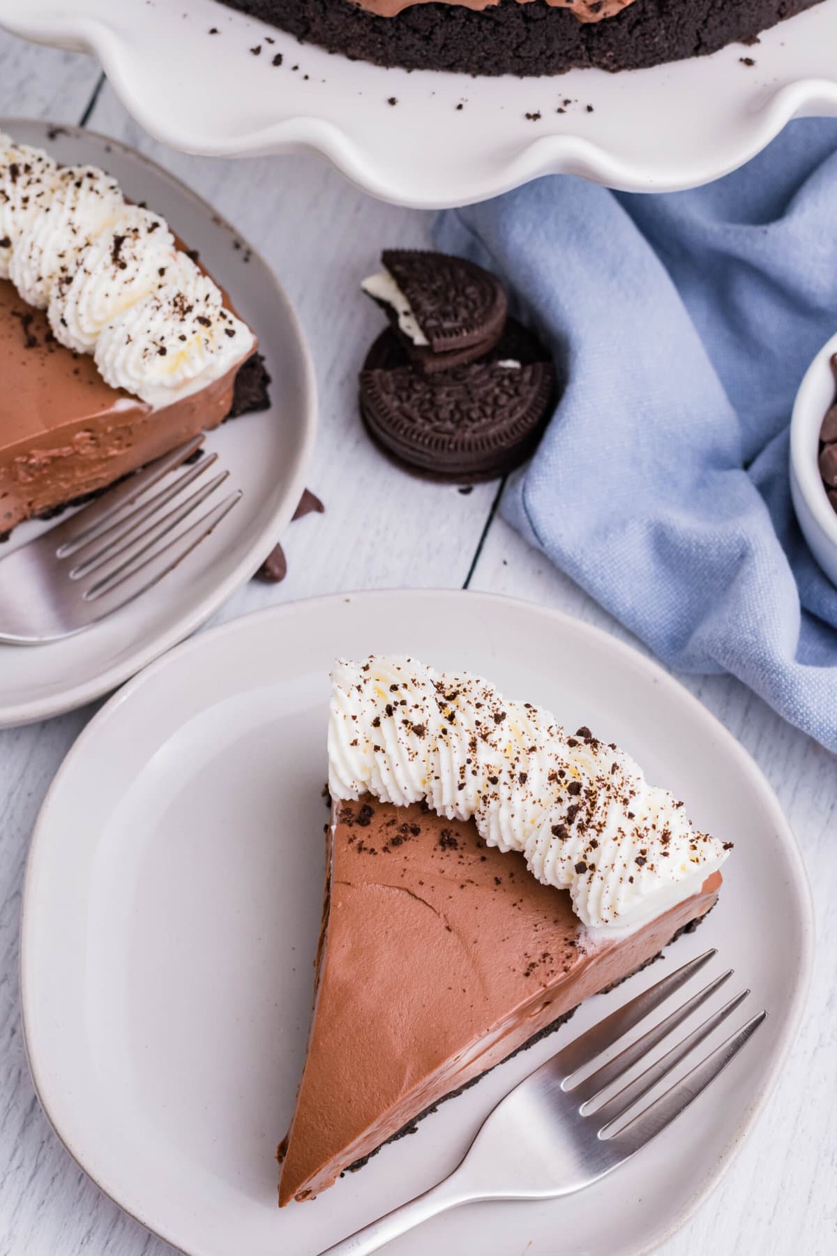 This No Bake Chocolate Cheesecake is just as rich and creamy as a traditional baked cheesecake, but so much easier to make! No Bake Chocolate Cheesecake on a white plate.