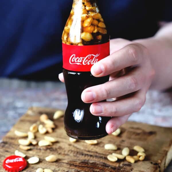a bottle of the recipe being held above a table.