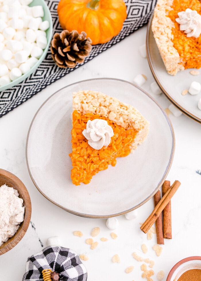 Pumpkin Rice Krispie Treats topped with cinnamon whipped cream.