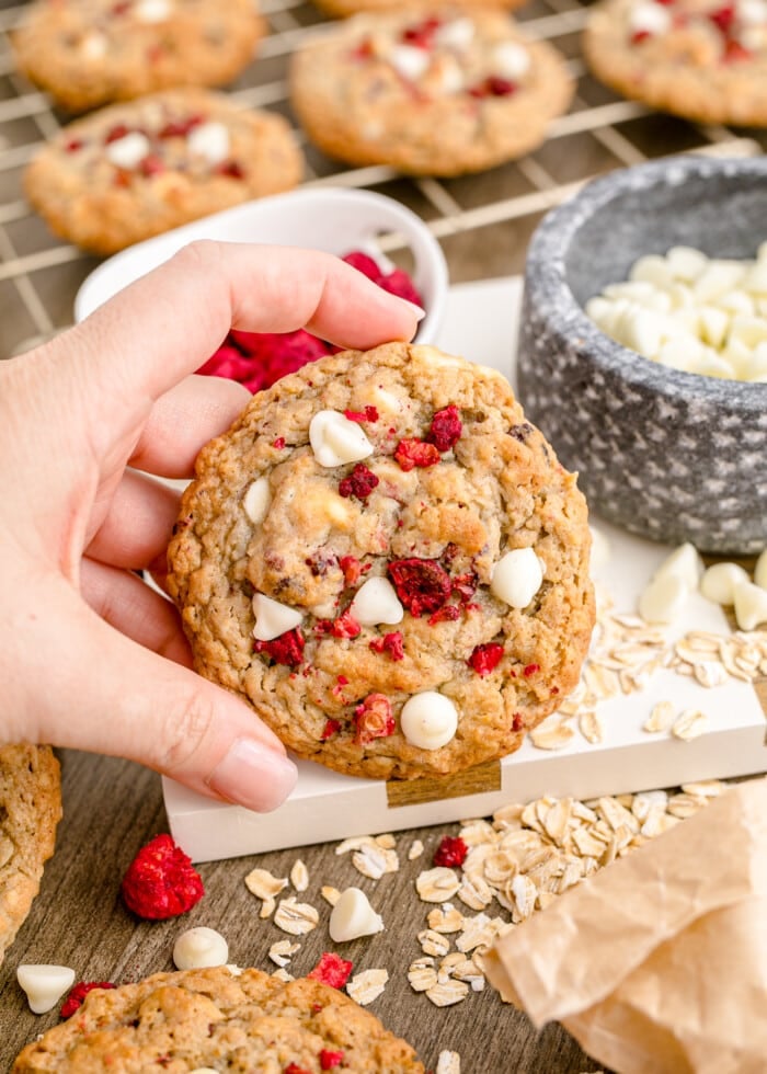 A hand holding the Raspberry Cookies with White Chocolate.