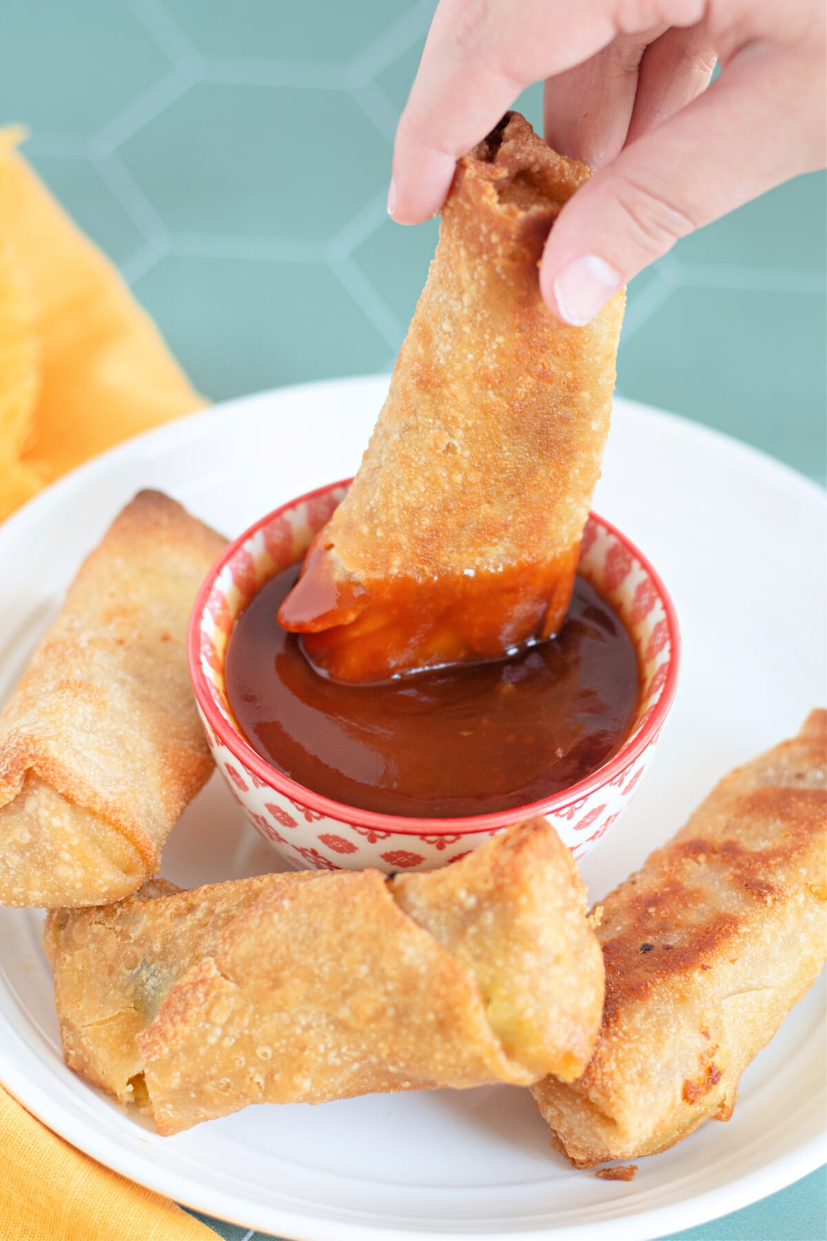 Dipping an Egg Roll into Sweet and Sour Sauce