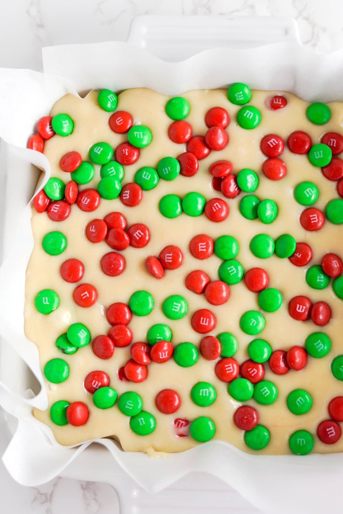 Adding the M&M's on top of the White Chocolate Christmas Fudge.