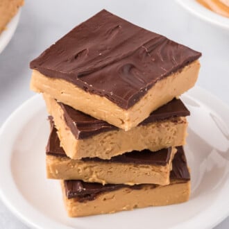 Overhead view of four buckeye bars stacked on a white plate.