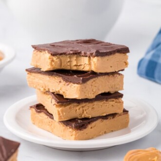 Four buckeye bars stacked on a white plate.